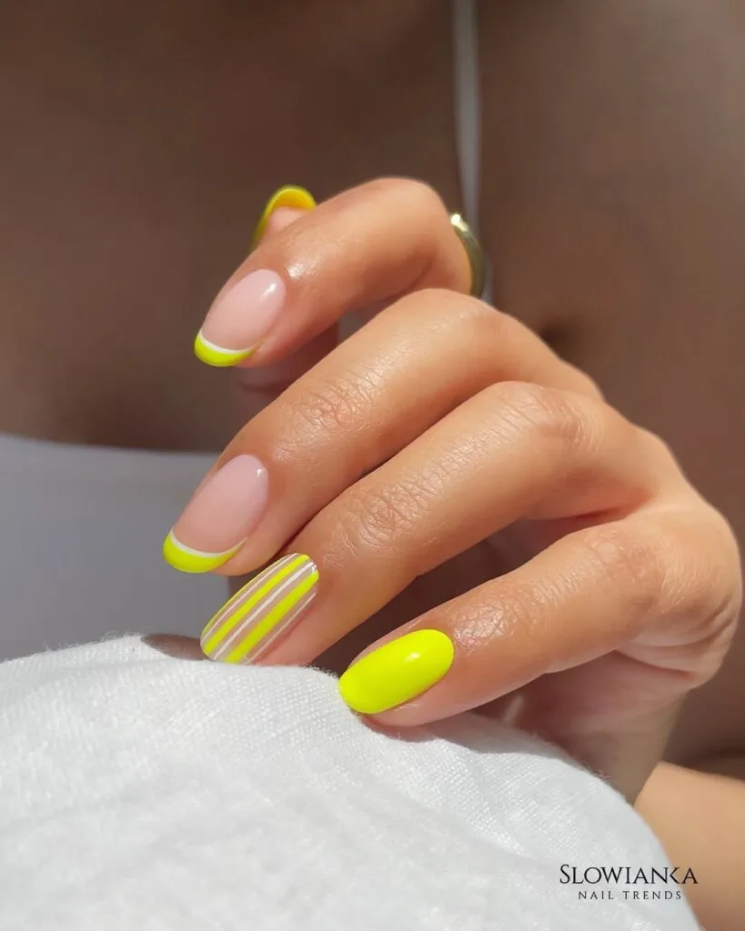  short summer nails, neon yellow French tips with white stripe accent nail on round shape, text "Slowianka Nail Trends"
