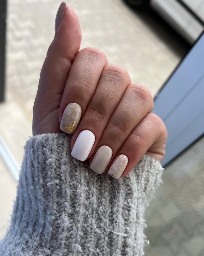 Short fall nails with neutral stone colors in white, beige, and taupe with gold foil accents