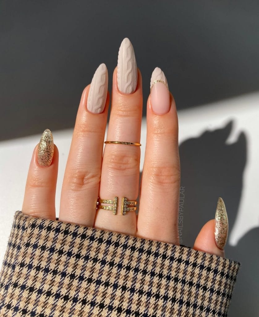 Long almond fall nails with cable knit texture in beige, soft pink, and gold glitter accents
