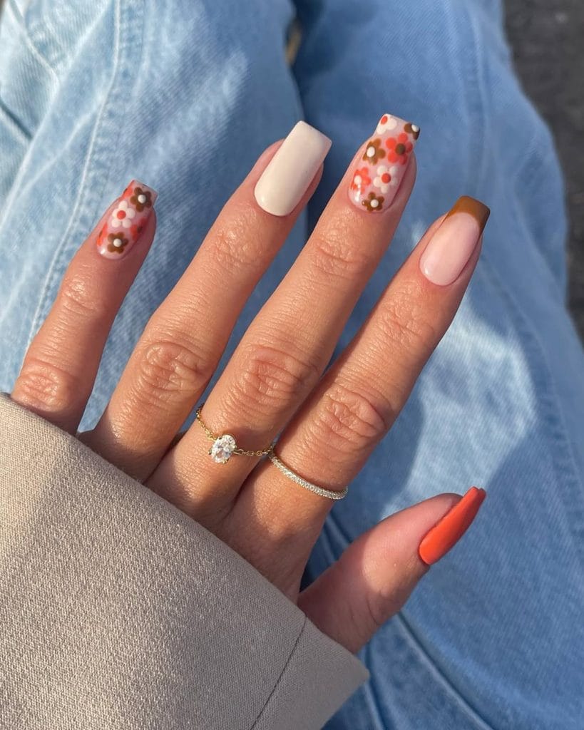 Short fall nails with neutral base colors and floral accent nails in orange, brown, and cream
