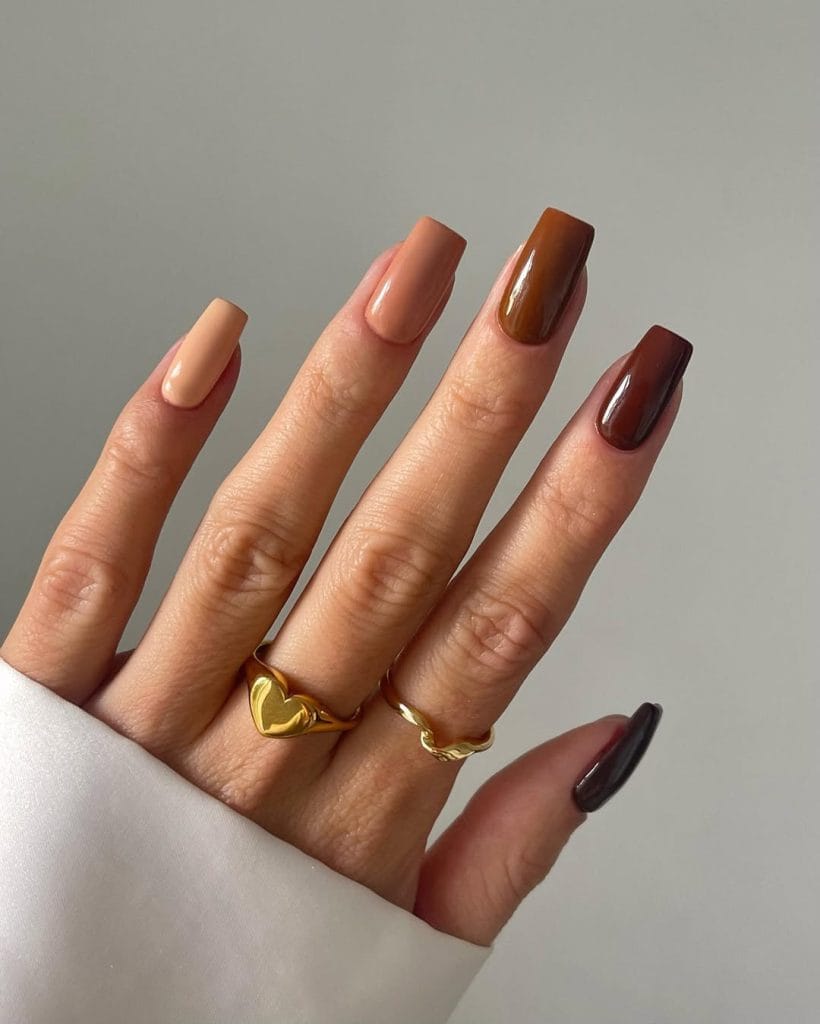 Long fall nails with gradient colors from cream to peach to brown to burgundy