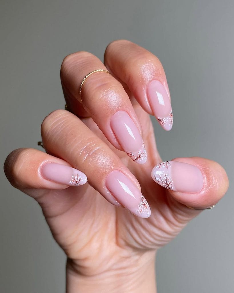 Long almond fall nails with sheer pink base and delicate white branch French tips