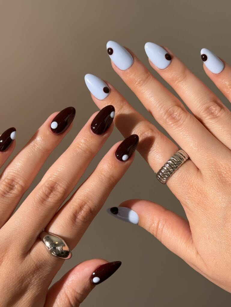 Almond fall nail ideas in espresso brown and periwinkle blue with a single dot on each nail
