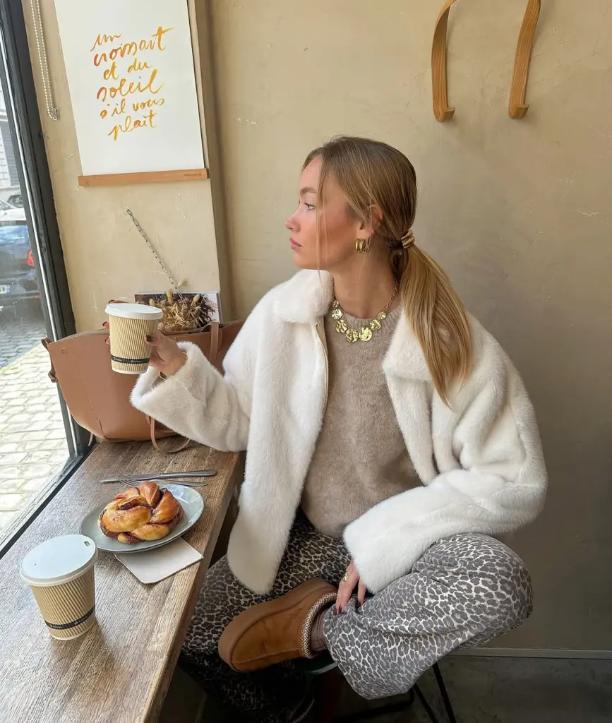 Cozy fall outfit with cream fuzzy coat over beige sweater and leopard print leggings, styled with gold statement necklace