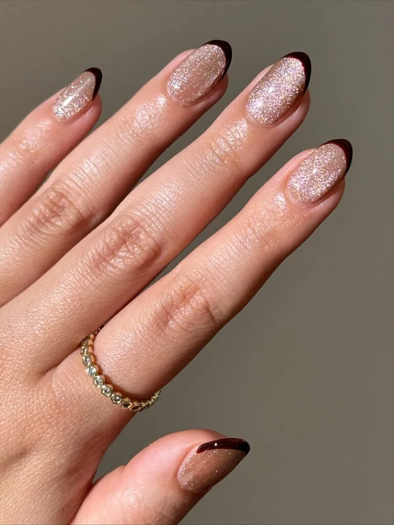 Champagne glitter oval nails with thin dark brown French tips, a simple fall nail idea.