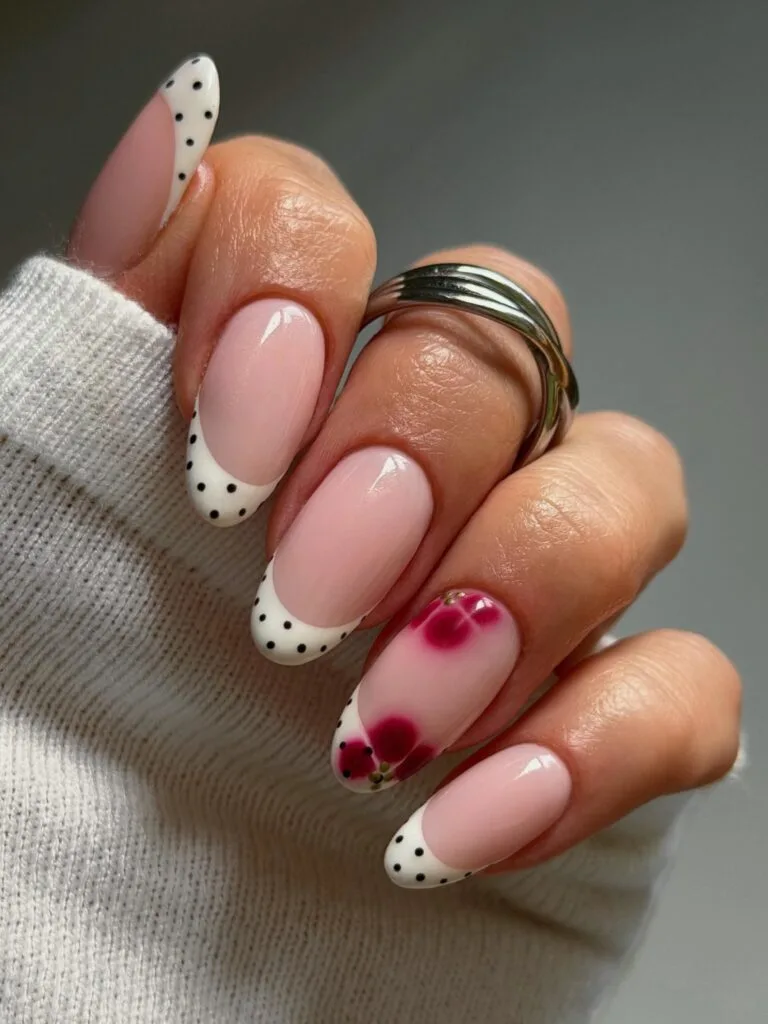 Almond fall French tip nails with pink bases, cream tips, black polka dots, and a berry floral accent.
