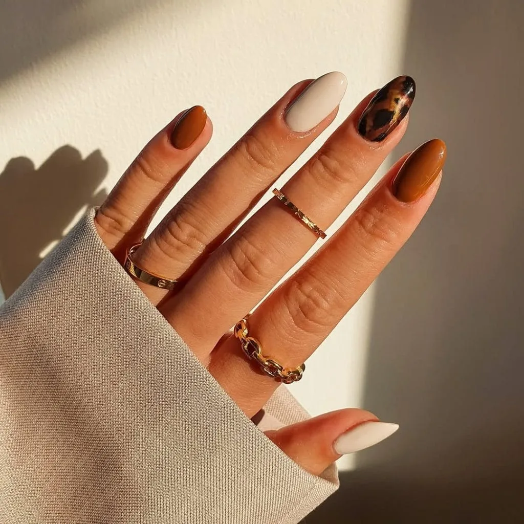 Classy fall nails in oval shape with burnt orange, nude, and tortoiseshell pattern
