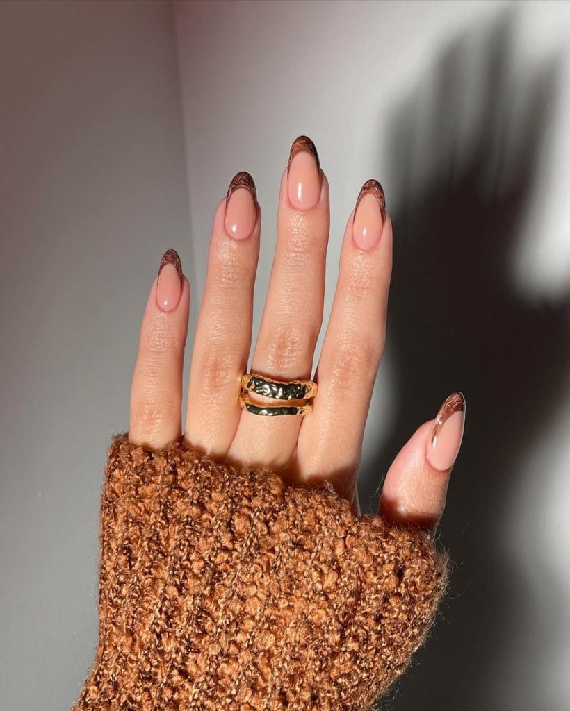 Marbled brown fall French tip nails on almond shaped nails with nude pink base
