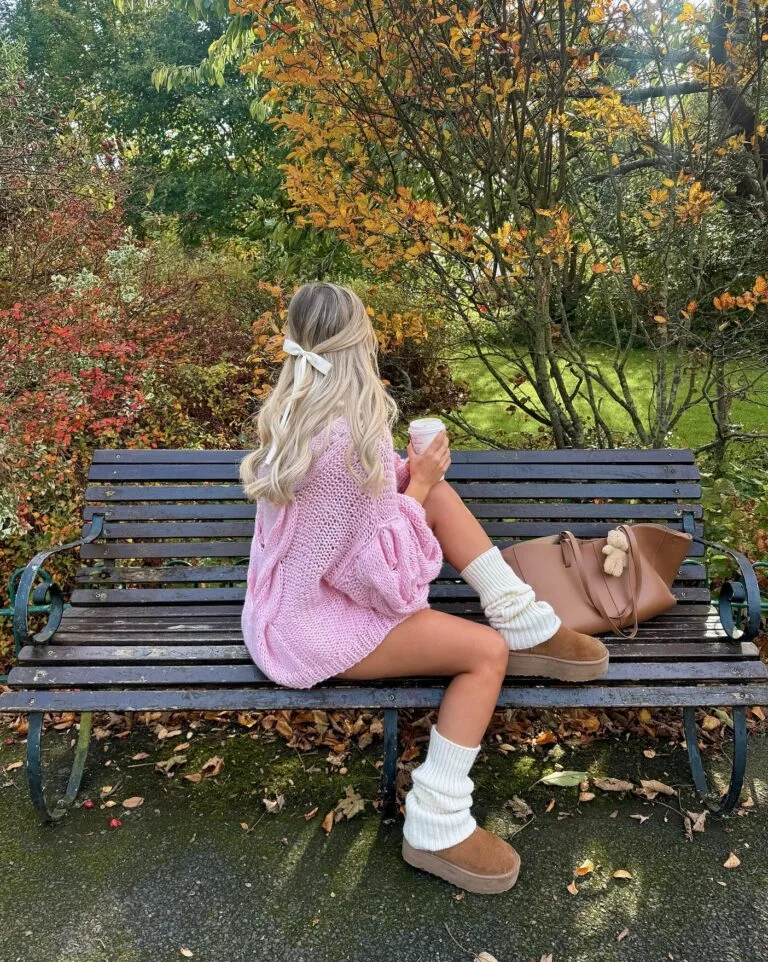 Cozy fall outfit with oversized pink knit, white leg warmers, tan UGGs, and brown tote.