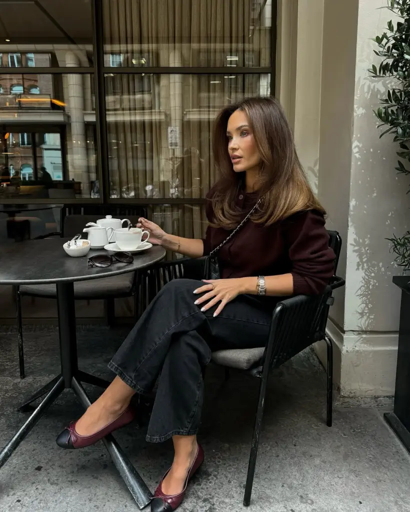 Cozy fall outfit with burgundy crewneck sweater, dark wash straight-leg jeans, burgundy ballet flats and black chain shoulder bag
