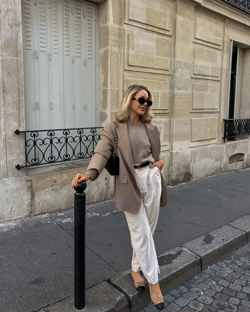 Chic old money outfit with taupe blazer, brown sweater, white trousers and cap-toe pumps