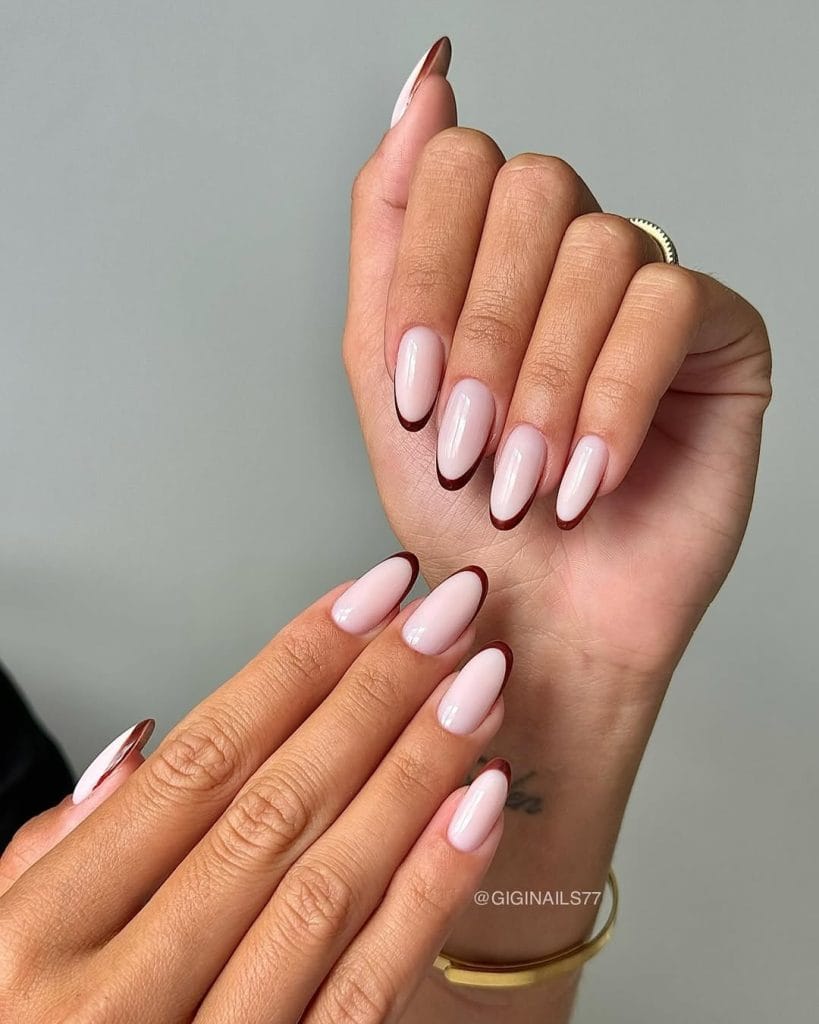 Deep burgundy fall French tip nails on oval shaped nails with rose pink base