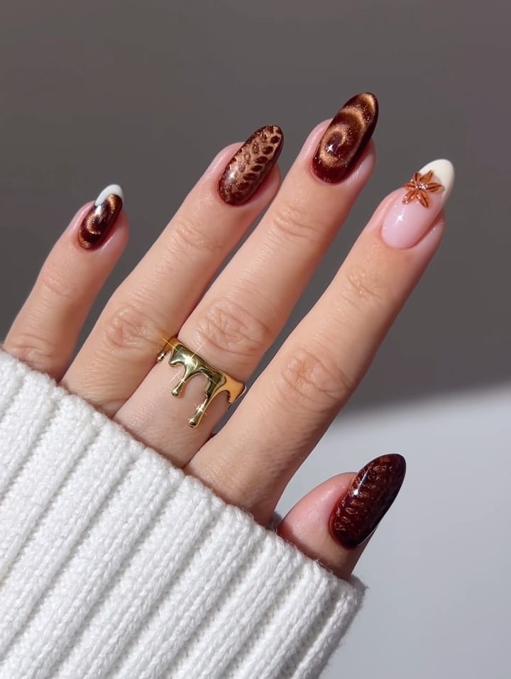 Brown fall nails with copper cat-eye swirls, textured cat-eye accents, a white French tip, and a 3D star anise charm
