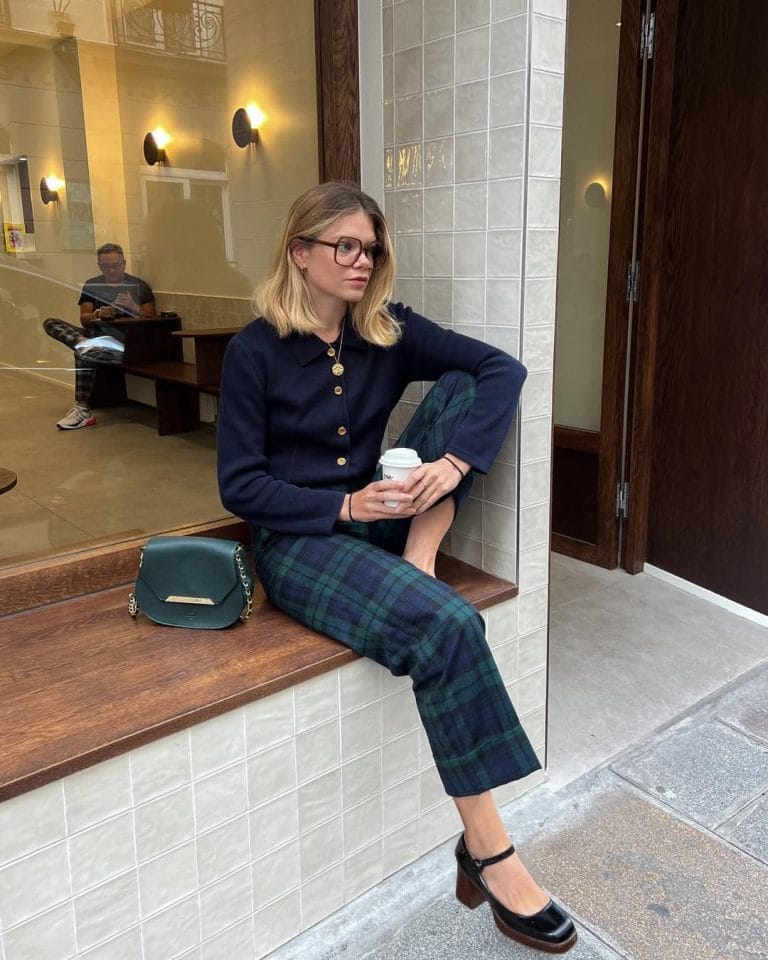 Parisian fall outfit with navy cardigan, tartan plaid pants, black mary jane heels
