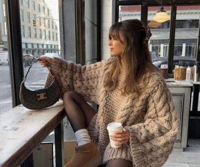 Cozy Ugg boots outfit with oversized cable knit sweater and black tights