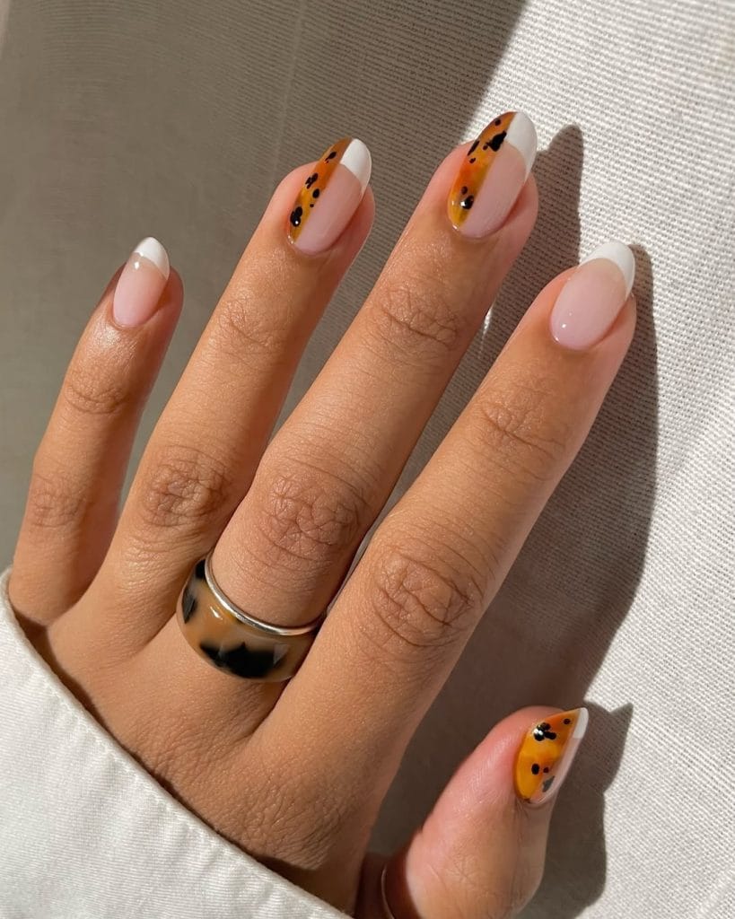 White fall French tip nails with orange tortoiseshell accent design on almond shaped nails