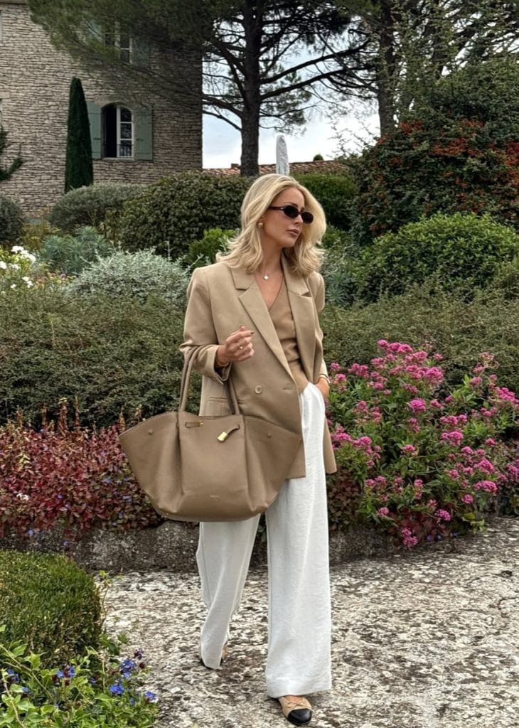 Chic fall work outfit with camel blazer, matching blouse, white wide-leg trousers and black cap-toe flats for office style