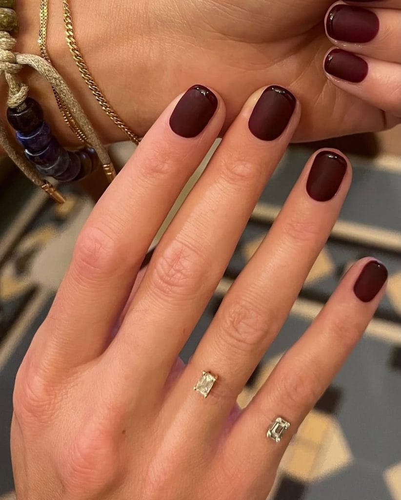 Matte burgundy fall French tip nails with glossy burgundy tips on short round nails