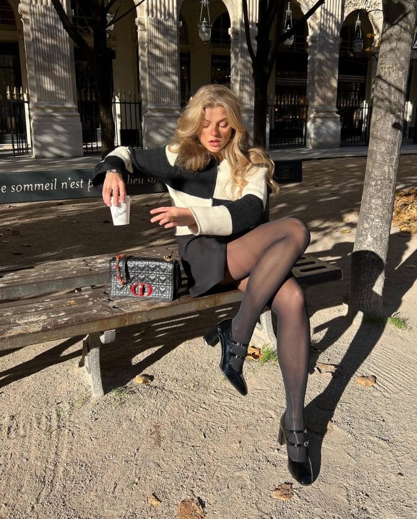 Parisian fall outfit with color block sweater, black mini skirt, mary jane heels
