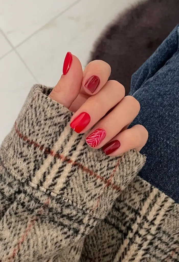 Short fall nail designs in mixed red shades with white leaf pattern accent nail