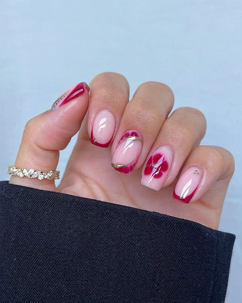 September nails with burgundy French tips, florals, and gold details