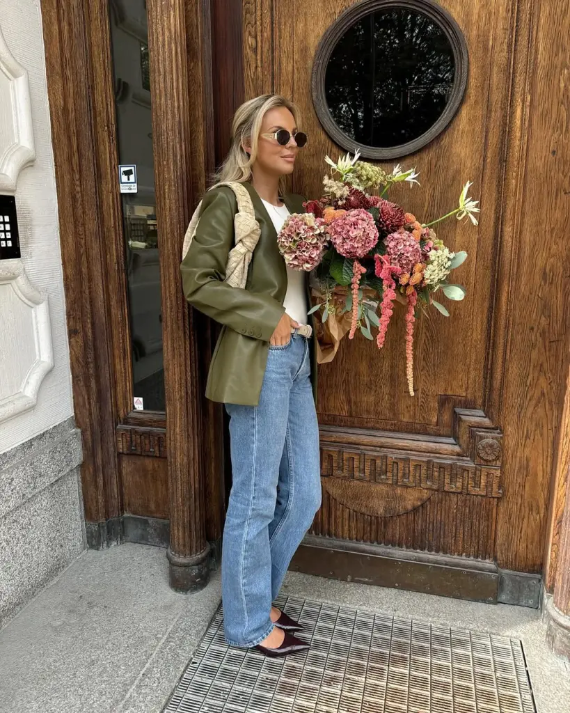 Chic fall outfit with olive structured blazer, white t-shirt, straight-leg jeans, burgundy ballet heels and woven shoulder bag
