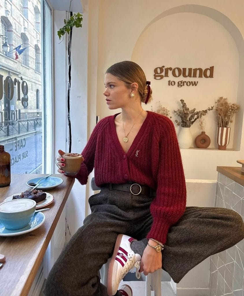 Parisian fall outfit with burgundy cardigan, grey tweed trousers, white sneakers

