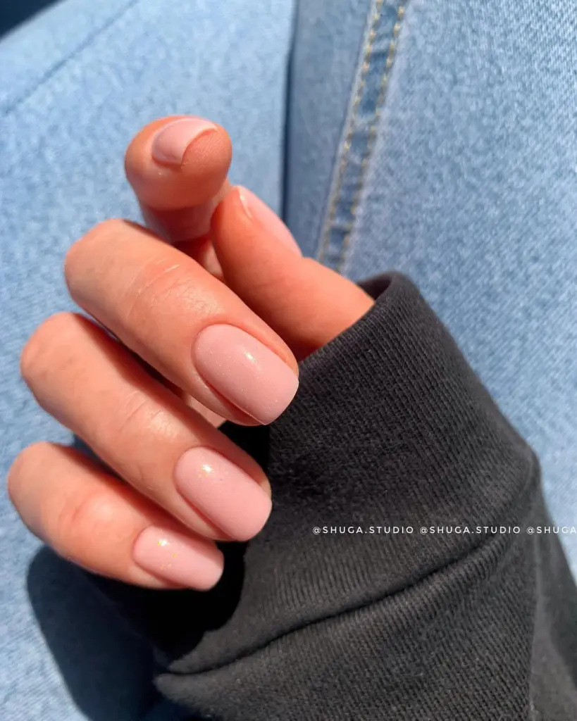 Warm peachy nude neutral nails with shimmer on short square shape