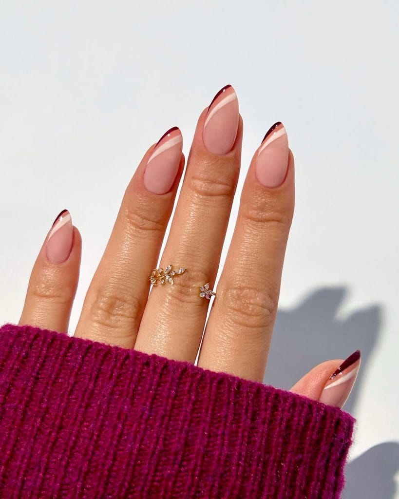 Diagonal fall French tip nails with cream beige and brown rainbow tips on almond shaped nails