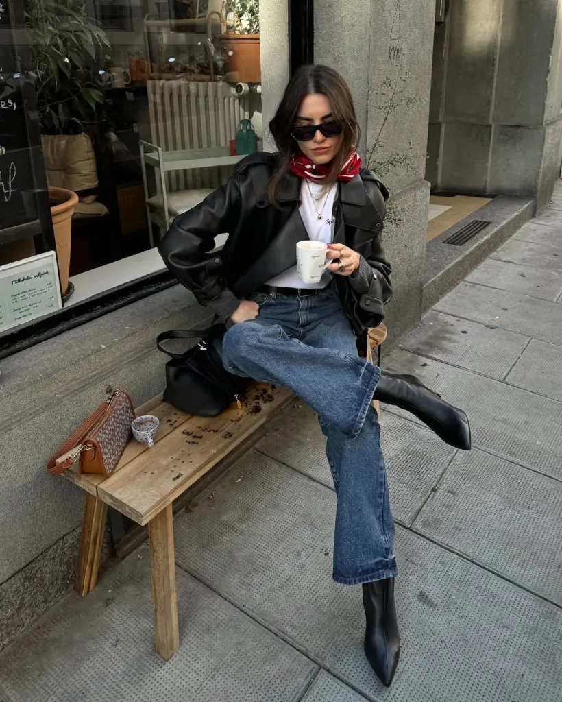Chic fall outfit with black leather jacket, red silk scarf, white t-shirt, straight-leg jeans, black pointed boots and brown shoulder bag
