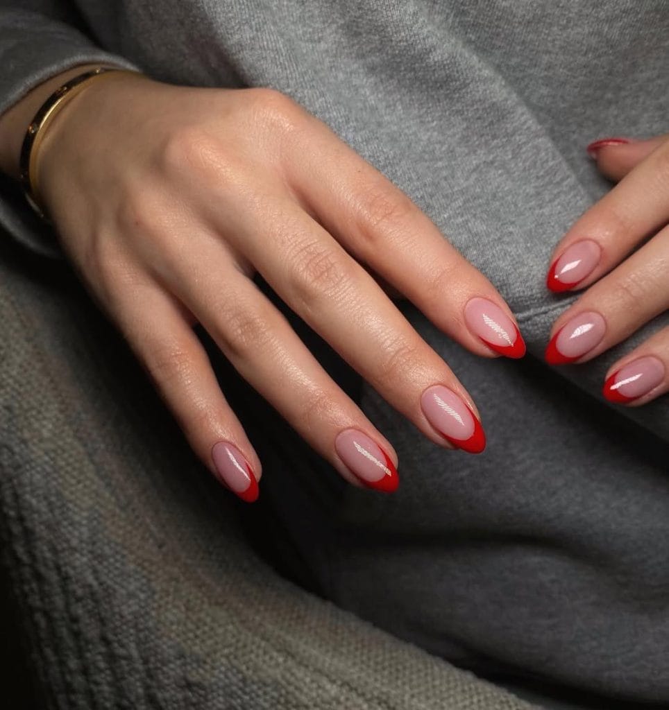 Bright red fall French tip nails on almond shaped nails with pink base