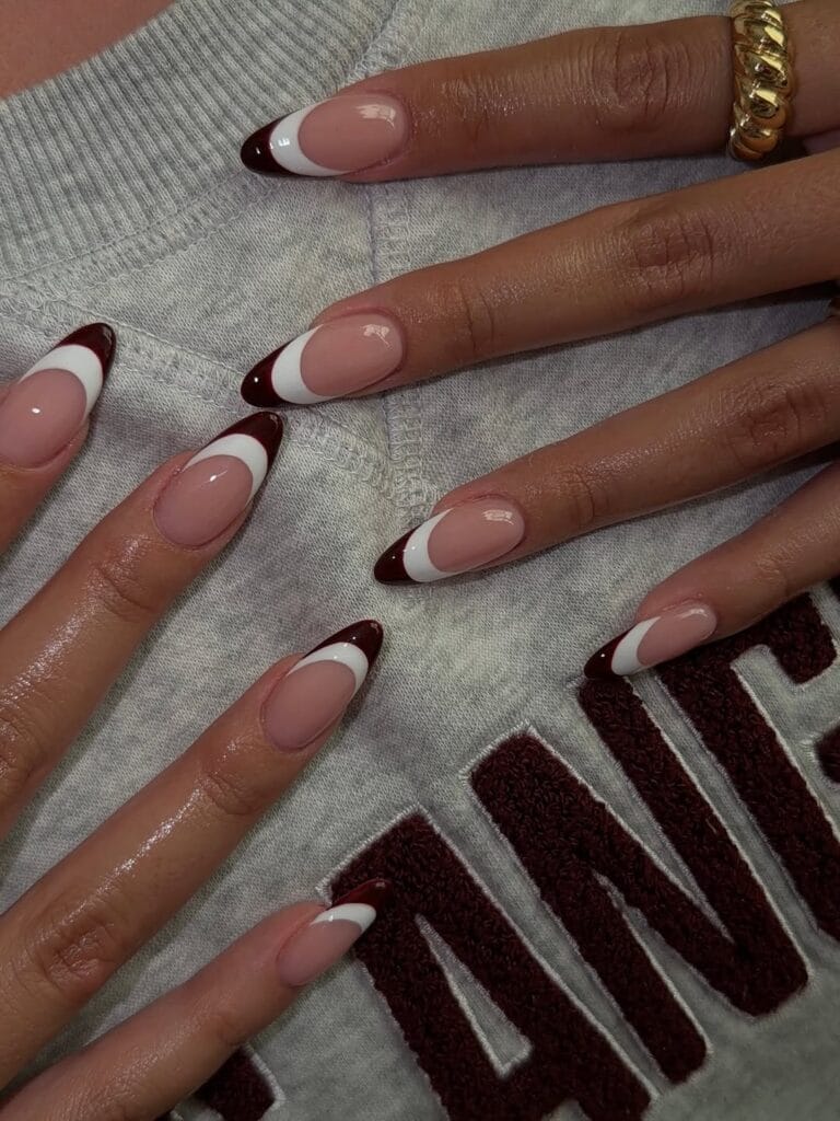 Almond nails with glossy nude pink bases and double French tips in white and dark brown.