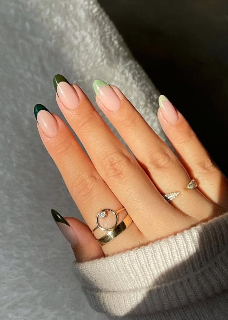 Mixed green fall French tip nails with forest sage and lime green tips on almond nails