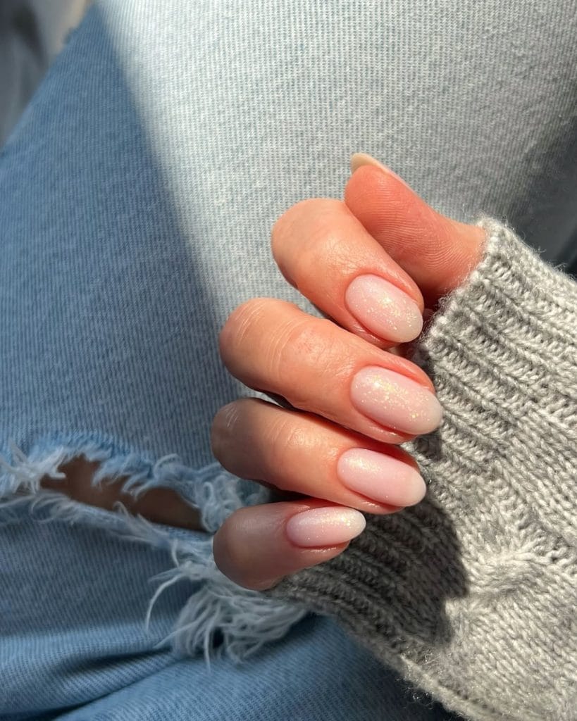 Oval nude September nails with golden shimmer finish