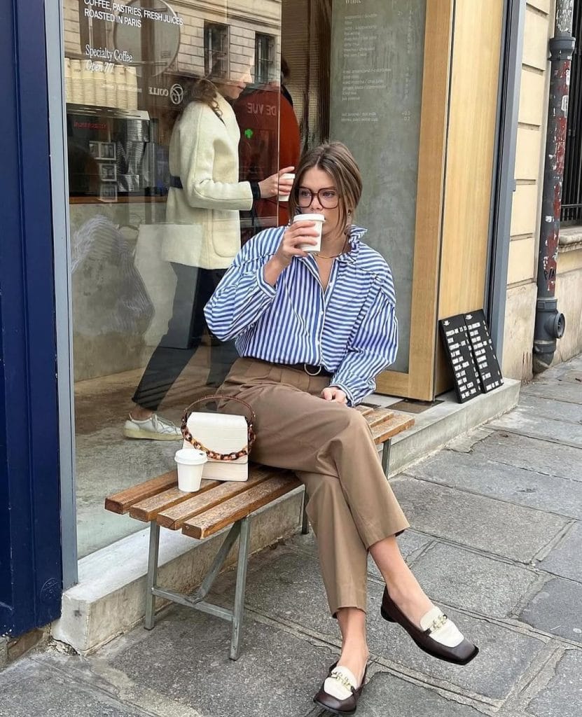 Casual fall work outfit with blue and white striped shirt, tan straight-leg trousers, and leopard print handbag for office style