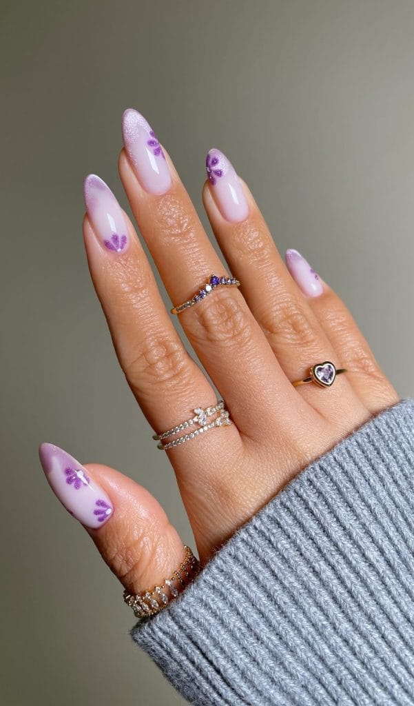 Long almond August nails with milky white base and purple cat eye French tips with flower accents