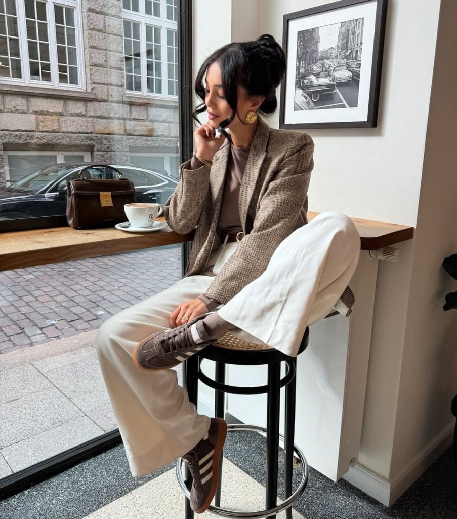 Smart fall work outfit with brown plaid blazer, cream wide-leg trousers and brown sneakers for office style