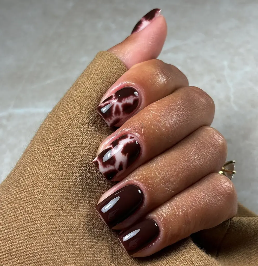 Fall short nails with brown and white cow print pattern design in glossy finish