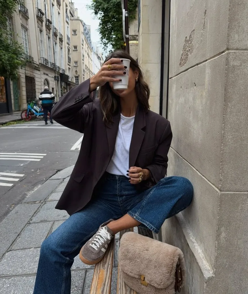  Casual fall outfit with dark brown blazer, white t-shirt, medium wash jeans, gray sneakers
