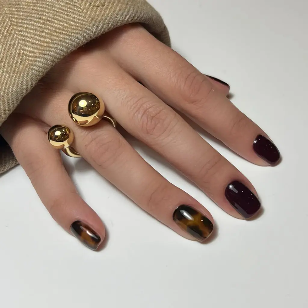 Short fall nails with tortoiseshell pattern and solid plum color mix in glossy finish