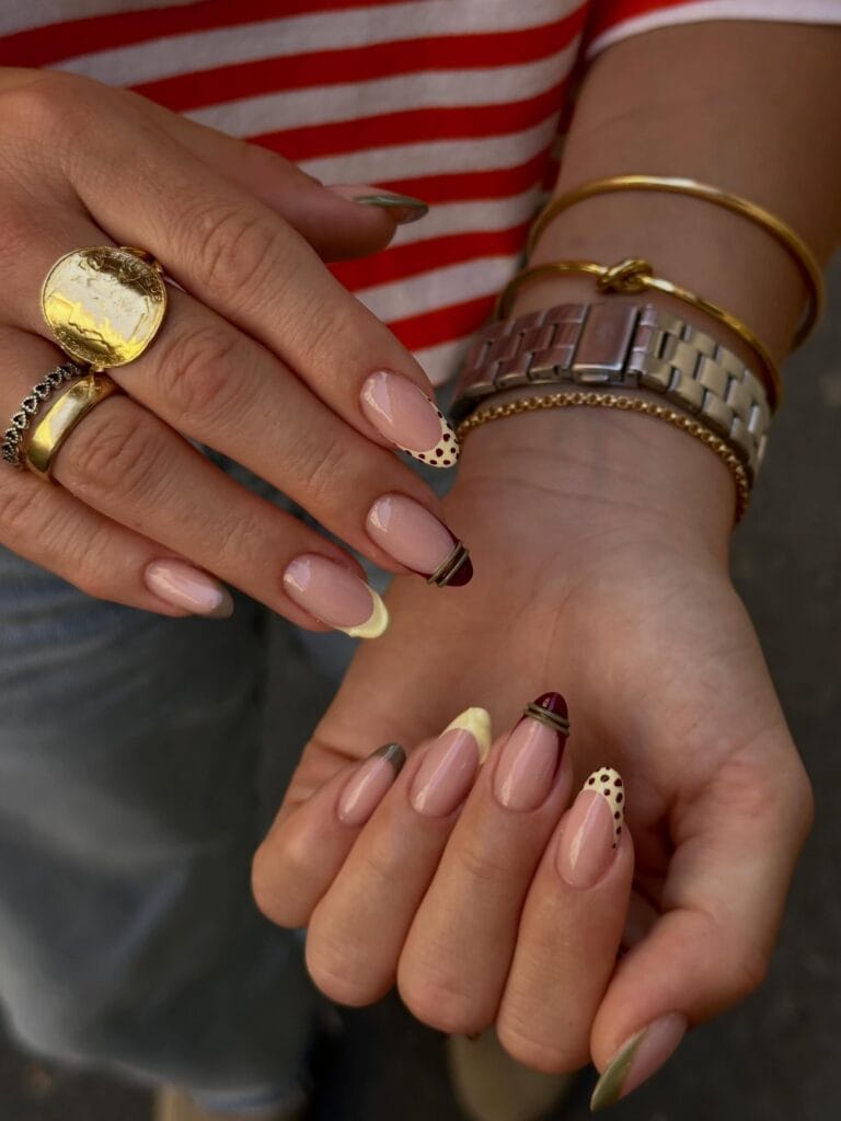 Fall French tip nails mixing olive, butter yellow, and burgundy with polka dots and raised stripes.
