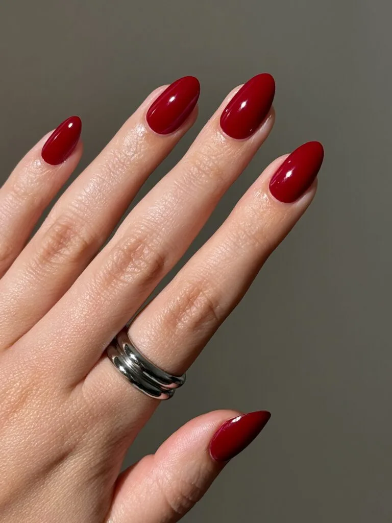 Elegant almond nails with deep cherry-red polish and a glossy finish.