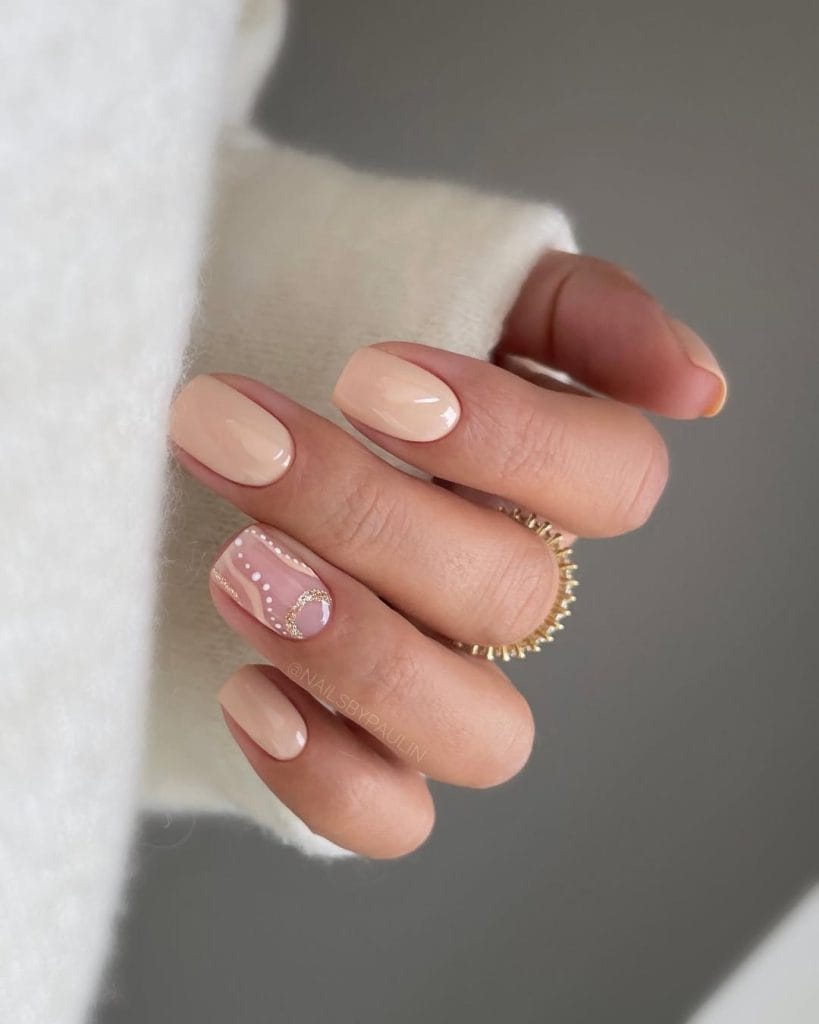 Short nude September nails with abstract art accent nail and gold details