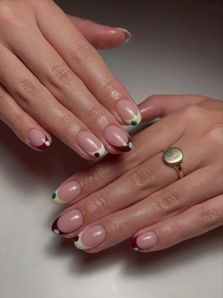 Short fall nails with burgundy, cream, and brown French tips plus green and pale blue dot accents.
