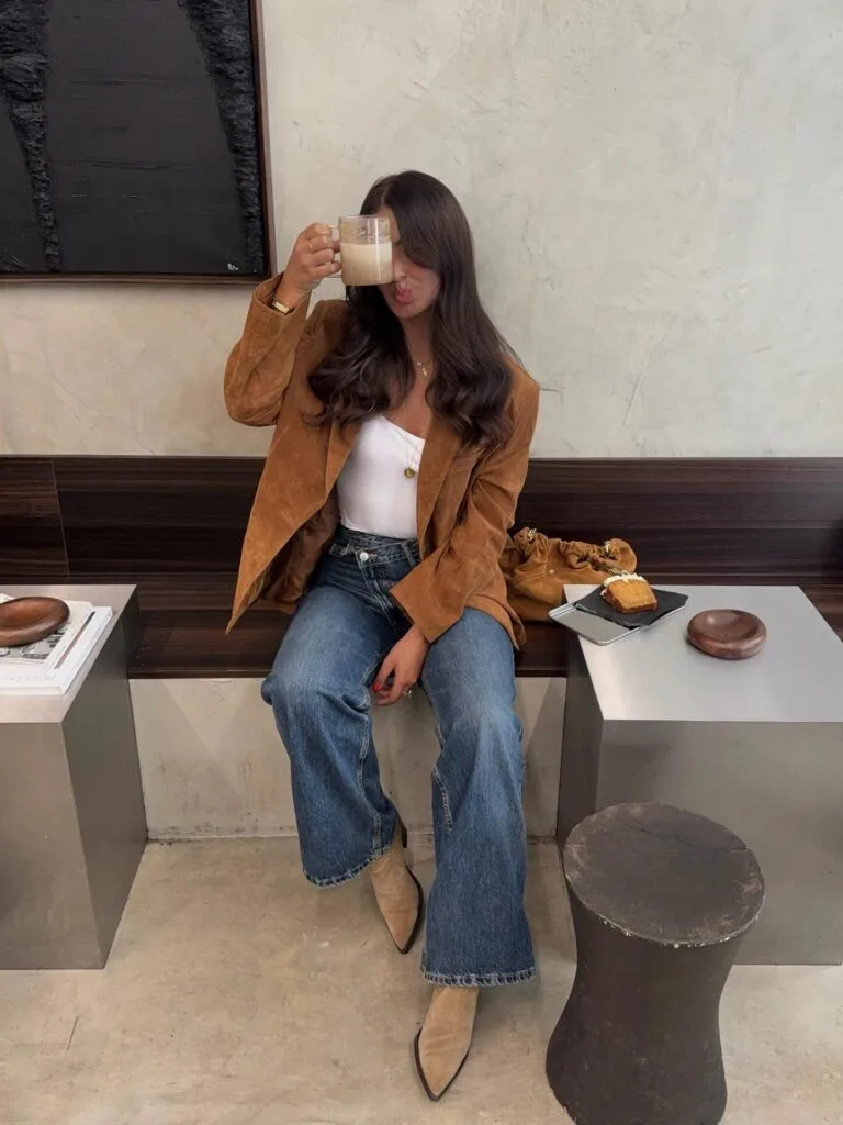 Casual autumn outfit with tan suede blazer, white top, wide-leg jeans, suede ankle boots, and suede bag
