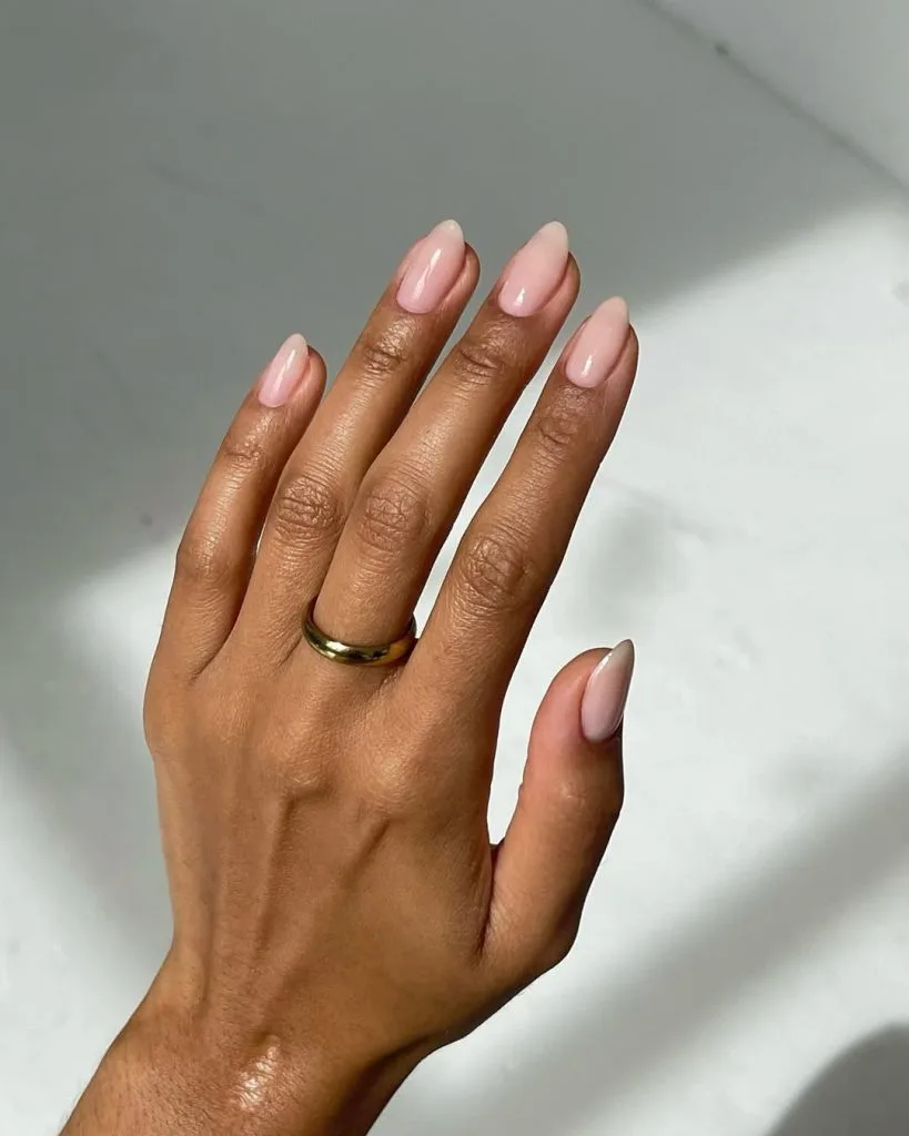 Oval nude pink old money fall nails in soft blush tone with gold ring