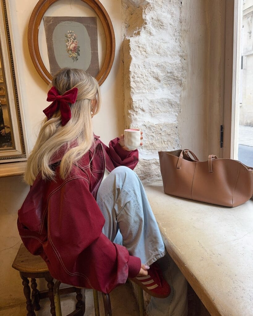 Everyday fall outfit with burgundy jacket, gray wide-leg sweatpants, red sneakers, and velvet hair bow.
