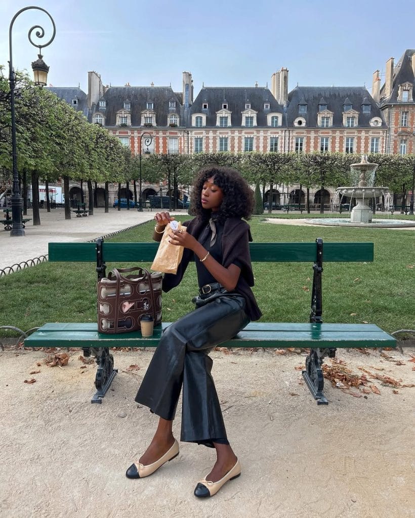 Parisian fall outfit with black wide-leg trousers, black top, cap-toe ballet flats
