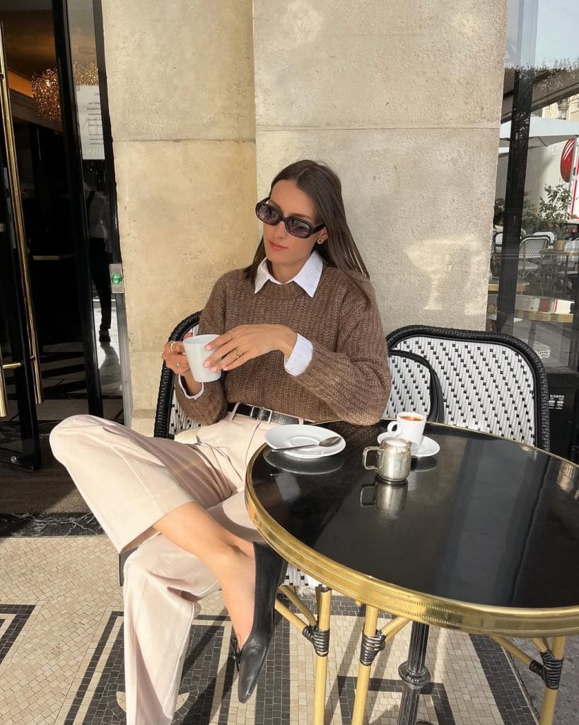 Fall work outfit with brown textured sweater, white collared shirt, and cream trousers