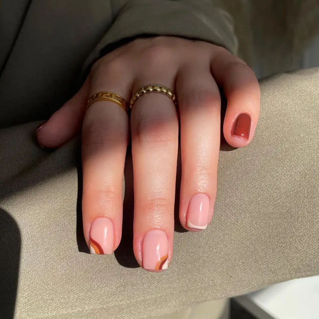 Short fall nail designs with burnt orange solid color, sheer pink base, cream French tips, and curved line nail art accents